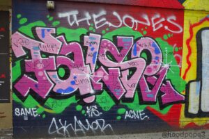 Graffiti on wall " False" in pink color